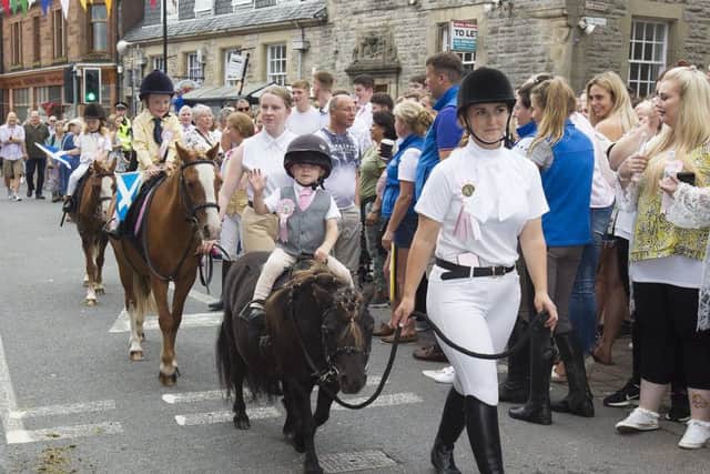 Rowan and Taylor Kerr follow the cornet at Langholm.