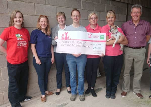 Borders Pet Rescue manager Lee-Ann Lackie (fourth from left) accepts the bumper cheque from Pets at Home's Catriona Curtis (second from left), watched by staff and volunteers from both organisations.