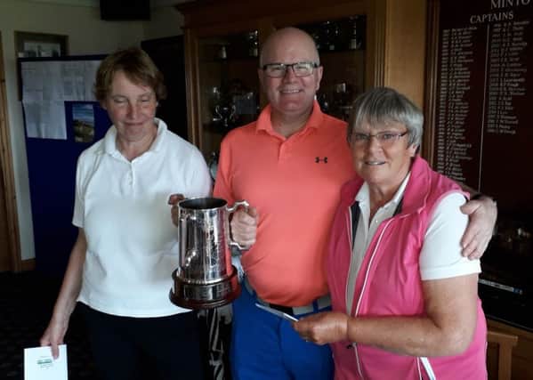 Winners of the Margaret Donaldson Memorial Trophy at Minto Golf club in Hawick, Margaret Bland and Allan Learmonth, are presented by Joyce Michie, right.