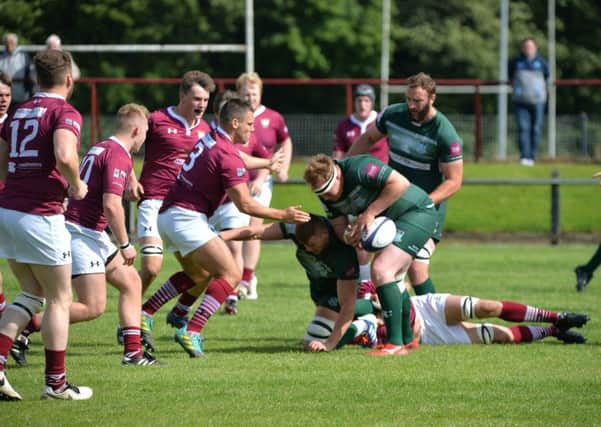 Hawick's Matt Carryer, with the ball (and an ex-Gala player) about to feel the weight of a tackle by Martin Christie (picture by Alwyn Johnston).