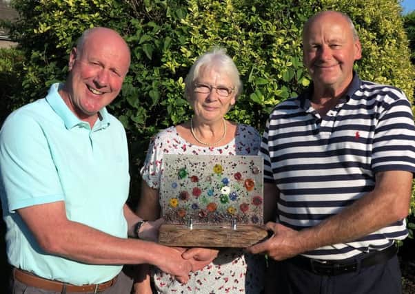 Winners of the St Boswells best garden competition, Irene and George Swinton, of 1 Inchdarnie Crescent, receive their trophy from Alan Marks, treasurer of the community council.