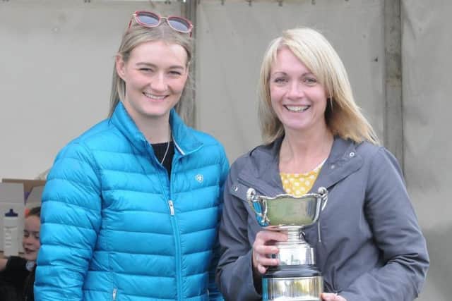Lesley Fairbairn receives the trophy for most points in the baking section from Amy Coltherd.
