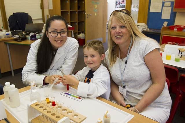 Six-year-old Angus Kirkness learning about neutralising acids with Melanie Filson and his favourite teacher Kirsty McRae, head of music.