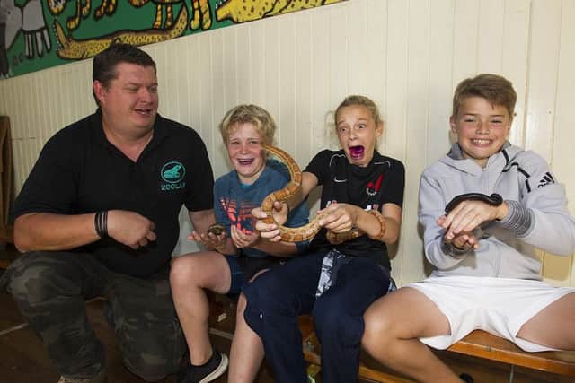 Tristan Ballantine, Tiggy Mattheson and Ollie DeGier nervously gett to grips with some critters from Tristan Bruce's zoolab.