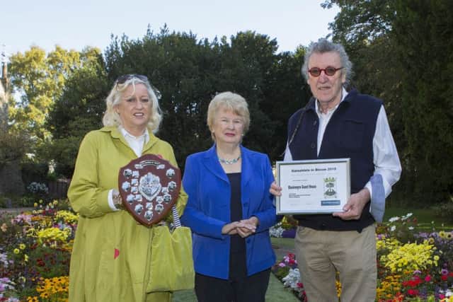 Judith Cleghorn (centre) presents the award for best commercial premises floral display to Carol and Bill Elliot.