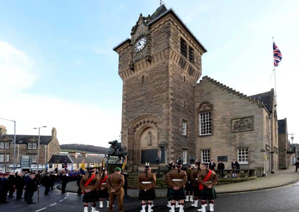 The parade osberves a two-minute silence as flags are dipped.