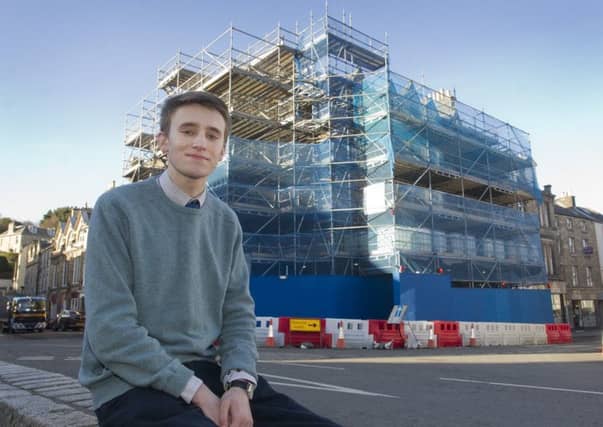 Jedburgh councillor Scott Hamilton in front of the town's scaffolding-clad building in the square.
