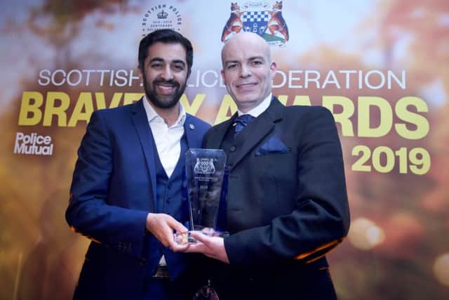 Ross Falconer being presented with his bravery award by Humza Yousaf. Photo: Sandy Young