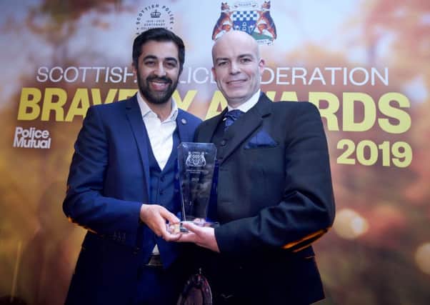 Ross Falconer being presented with his bravery award by Humza Yousaf. Photo: Sandy Young
